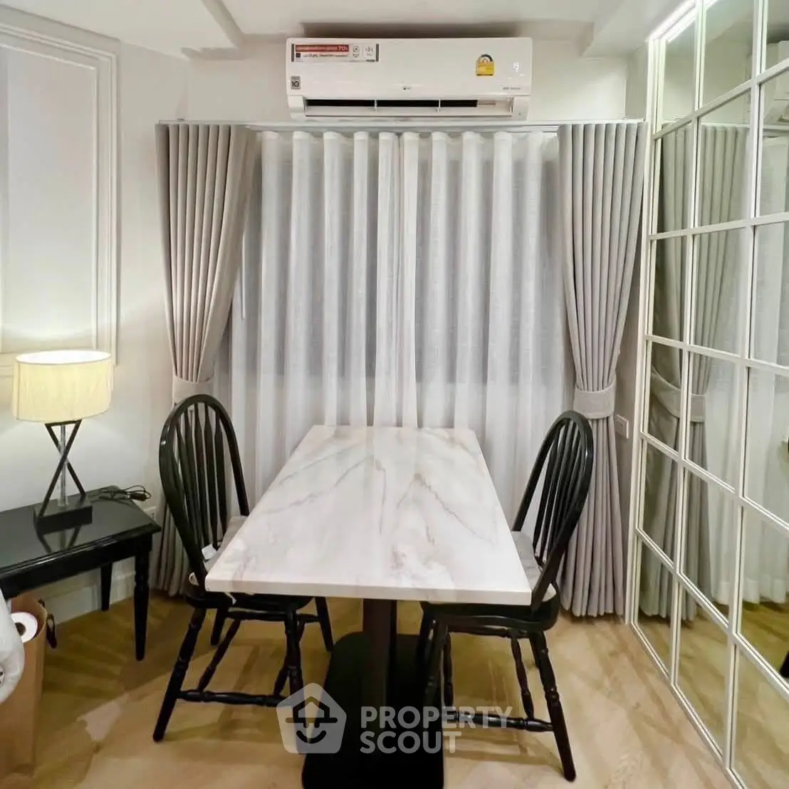 Charming dining nook with elegant marble table and cozy seating, perfect for intimate meals in a stylish home.