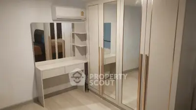 Modern bedroom with mirrored wardrobe and sleek vanity in a stylish apartment.
