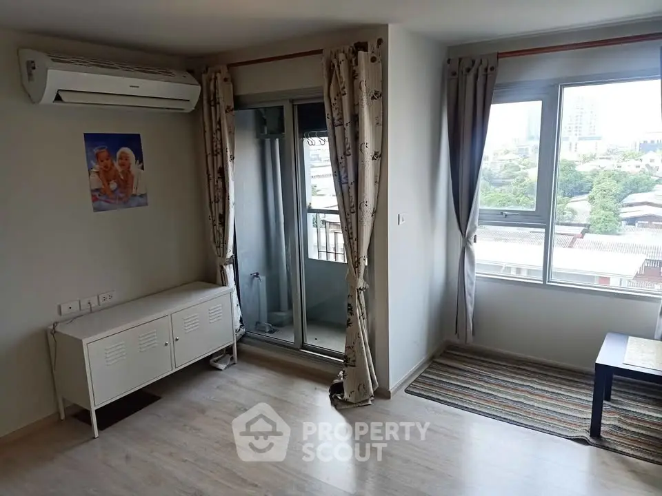Bright living room with balcony access and air conditioning in modern apartment.