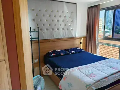 Cozy bedroom with elegant headboard and large window offering city views