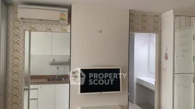 Modern apartment interior with sleek kitchen and wall-mounted TV