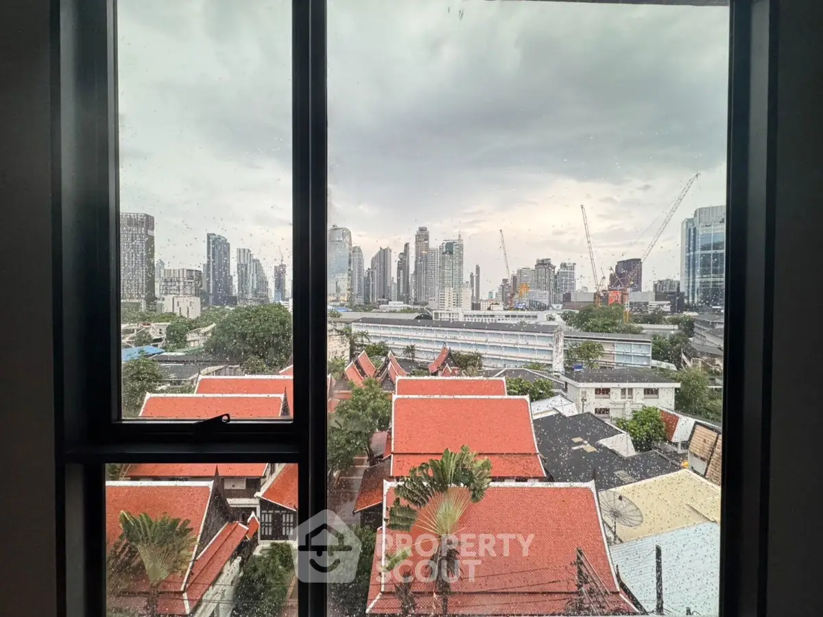 Stunning cityscape view from a window showcasing urban skyline and traditional rooftops.