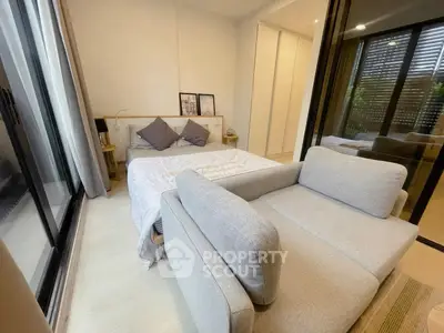 Cozy bedroom with modern decor and large windows for natural light.