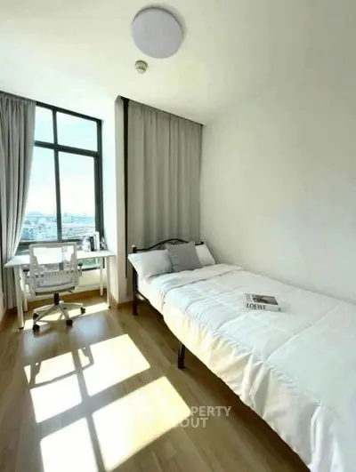 Bright minimalist bedroom with single bed and study desk, large window view.