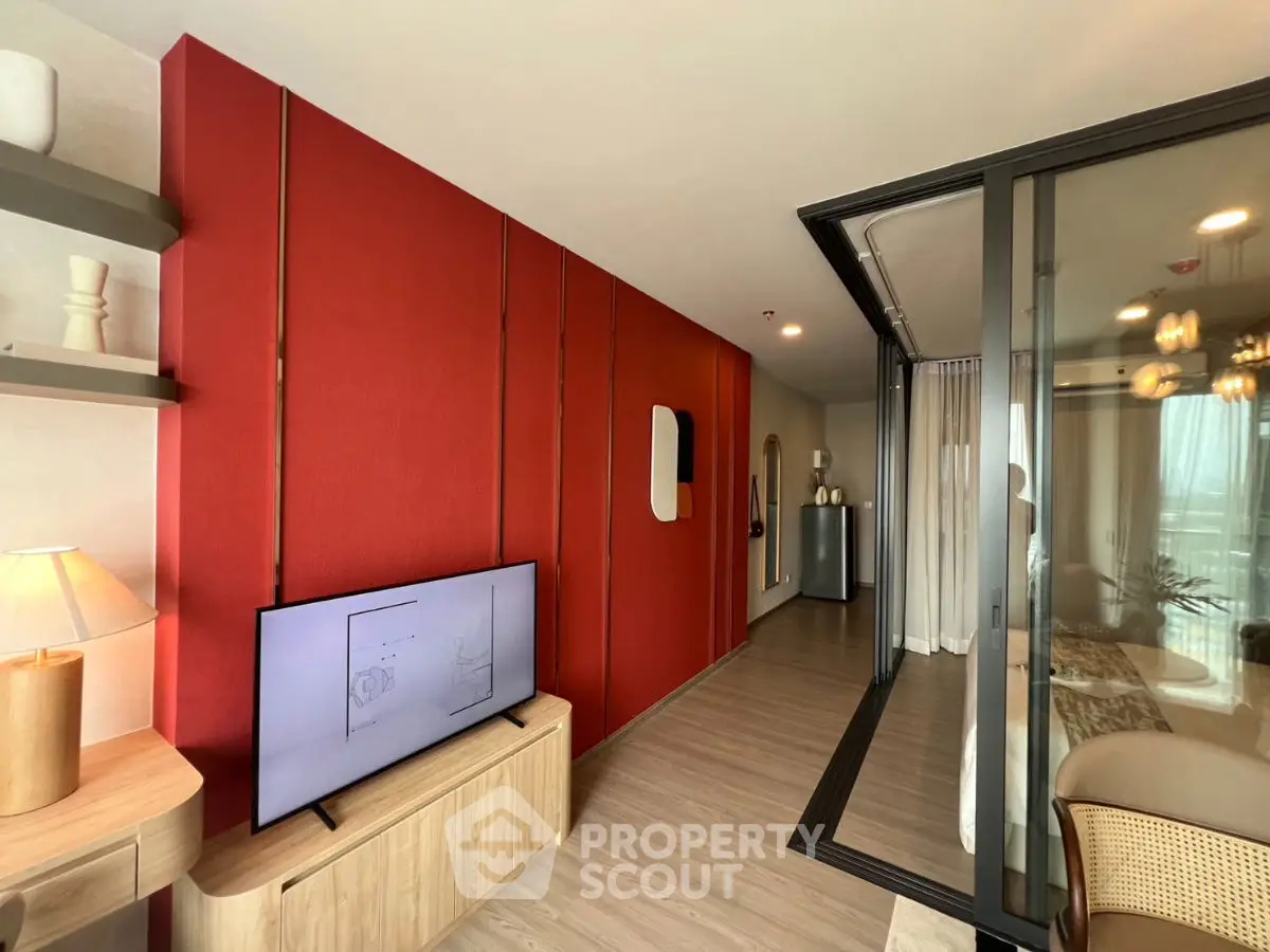 Modern living room with red accent wall and sliding glass doors