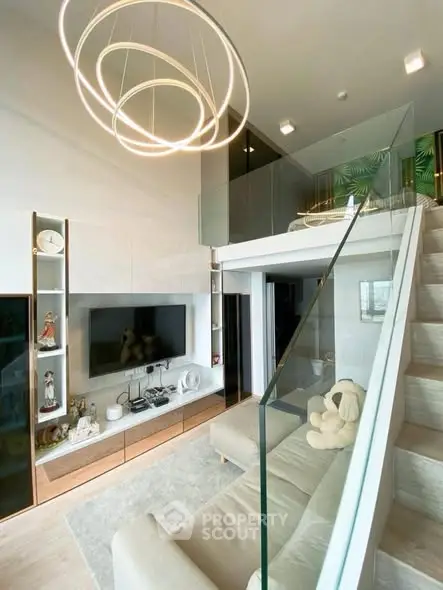 Modern loft living room with stylish lighting and glass railing, featuring a cozy sofa and elegant decor.