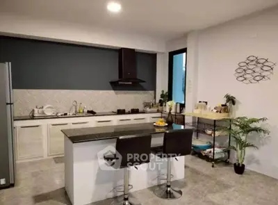 Modern kitchen with island, sleek cabinetry, and stylish decor in a contemporary home.