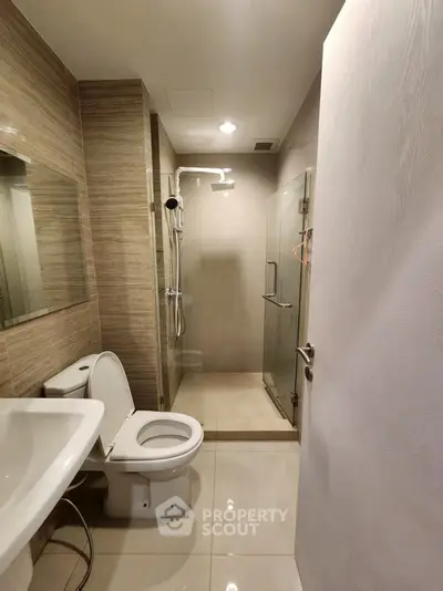 Modern bathroom with sleek shower and elegant fixtures in contemporary home.