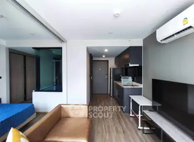 Modern studio apartment with open layout, featuring a cozy living area, sleek kitchen, and stylish decor.