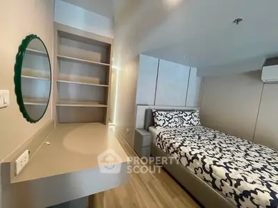 Modern bedroom with stylish decor and built-in shelves, perfect for urban living.
