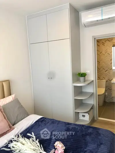 Modern bedroom with built-in wardrobe and ensuite bathroom, featuring sleek design and cozy decor.