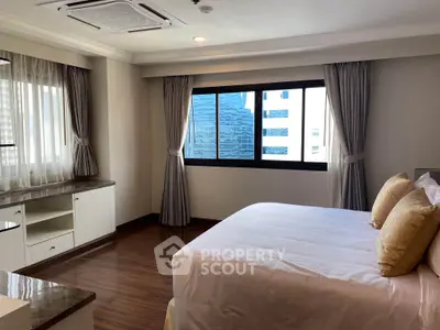 Spacious bedroom with large window and elegant decor in modern apartment