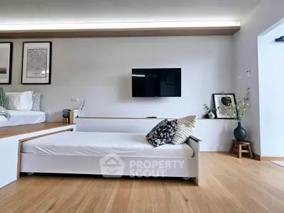 Modern living room with sleek design, featuring a stylish daybed and wall-mounted TV for ultimate comfort.