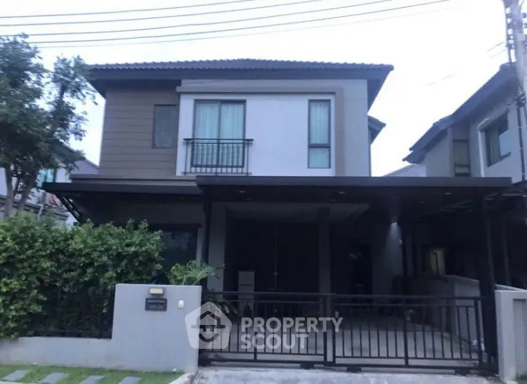 Charming two-story home with a welcoming entrance, featuring a spacious balcony and a covered parking area, nestled in a serene neighborhood.