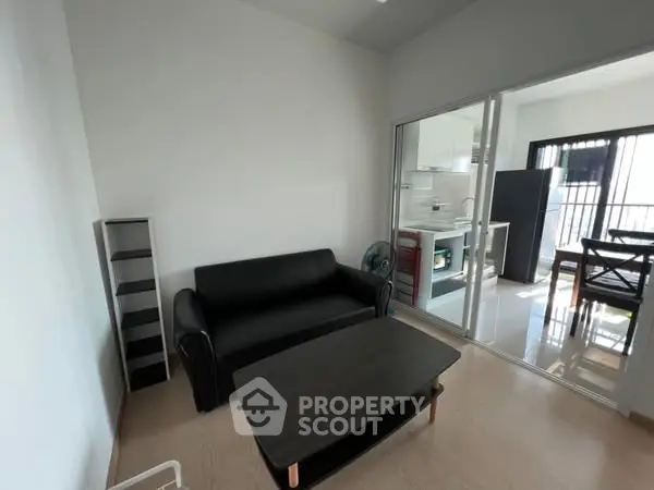 Modern living room with black sofa and open kitchen layout
