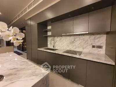 Luxurious modern kitchen with sleek cabinetry and marble countertops in a high-end apartment.