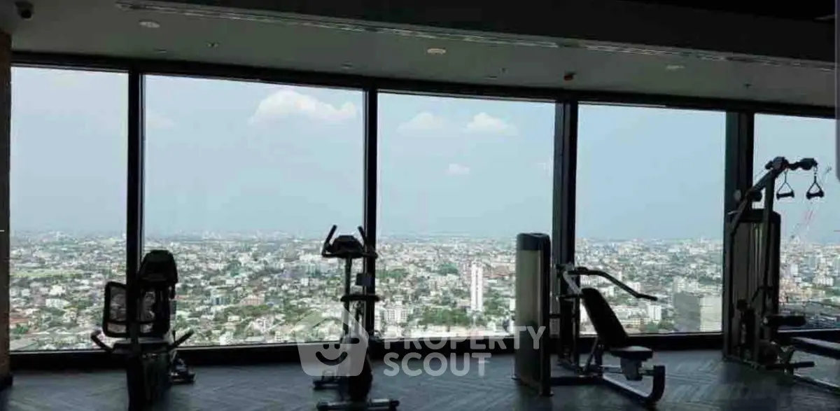 Luxurious gym with panoramic city views and modern fitness equipment.