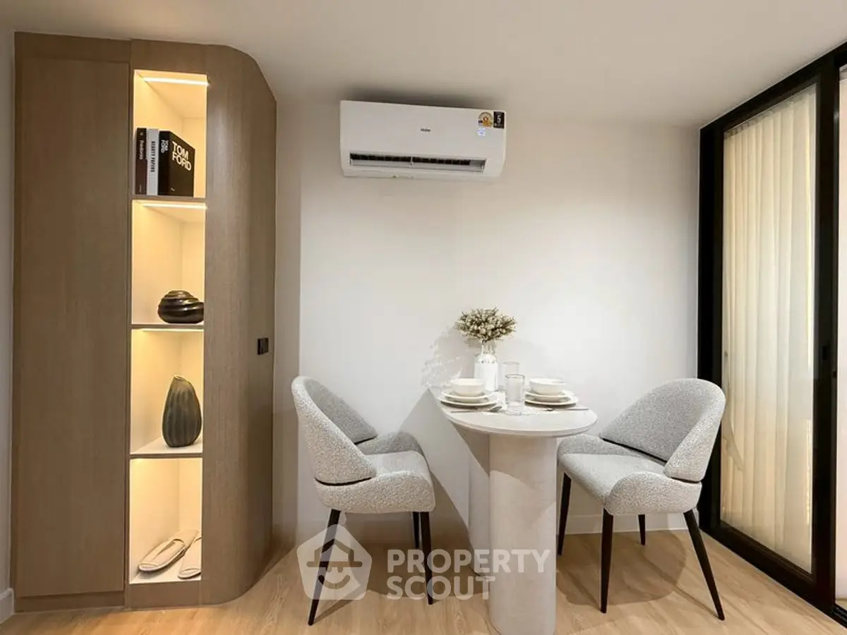Modern dining nook with elegant table and chairs under sleek air conditioning unit.