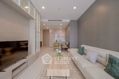 Modern living room with sleek furniture and neutral tones, featuring a cozy sofa and stylish decor.