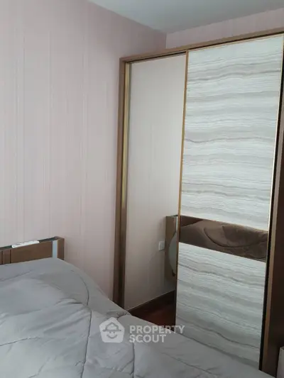 Cozy bedroom with modern sliding wardrobe and soft bedding