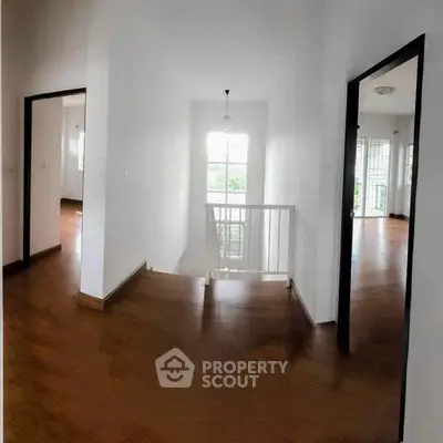 Spacious hallway with wooden flooring and natural light