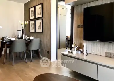 Modern living room with dining area, stylish decor, and wall-mounted TV in elegant apartment.