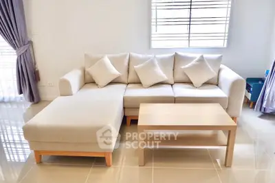 Modern living room with stylish beige sectional sofa and wooden coffee table, perfect for cozy gatherings.