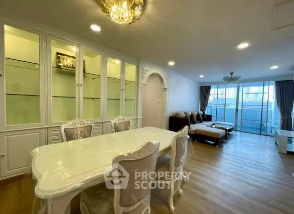 Elegant living room with dining area, featuring classic furniture and large windows for natural light.
