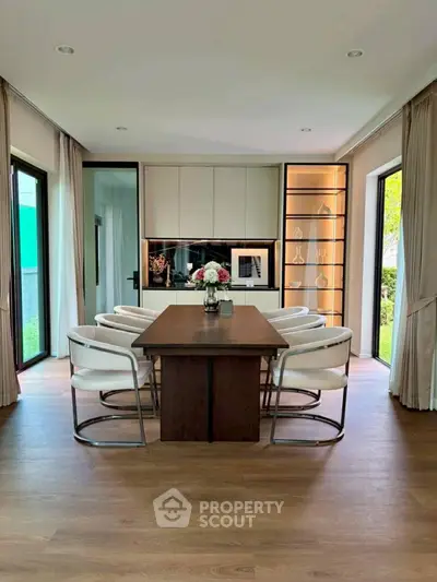 Elegant dining room with modern decor and large windows overlooking garden.