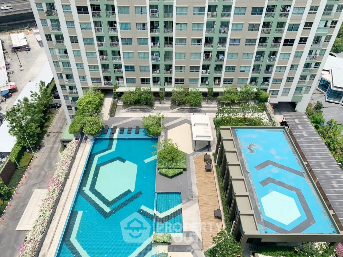 Modern apartment building with two stylish swimming pools and landscaped gardens.