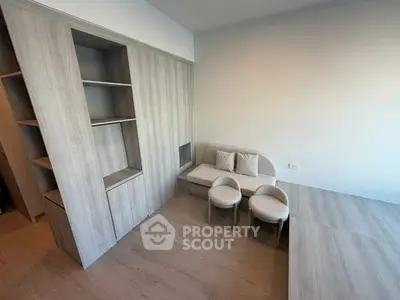 Modern minimalist living room with built-in wooden shelves and cozy seating area.