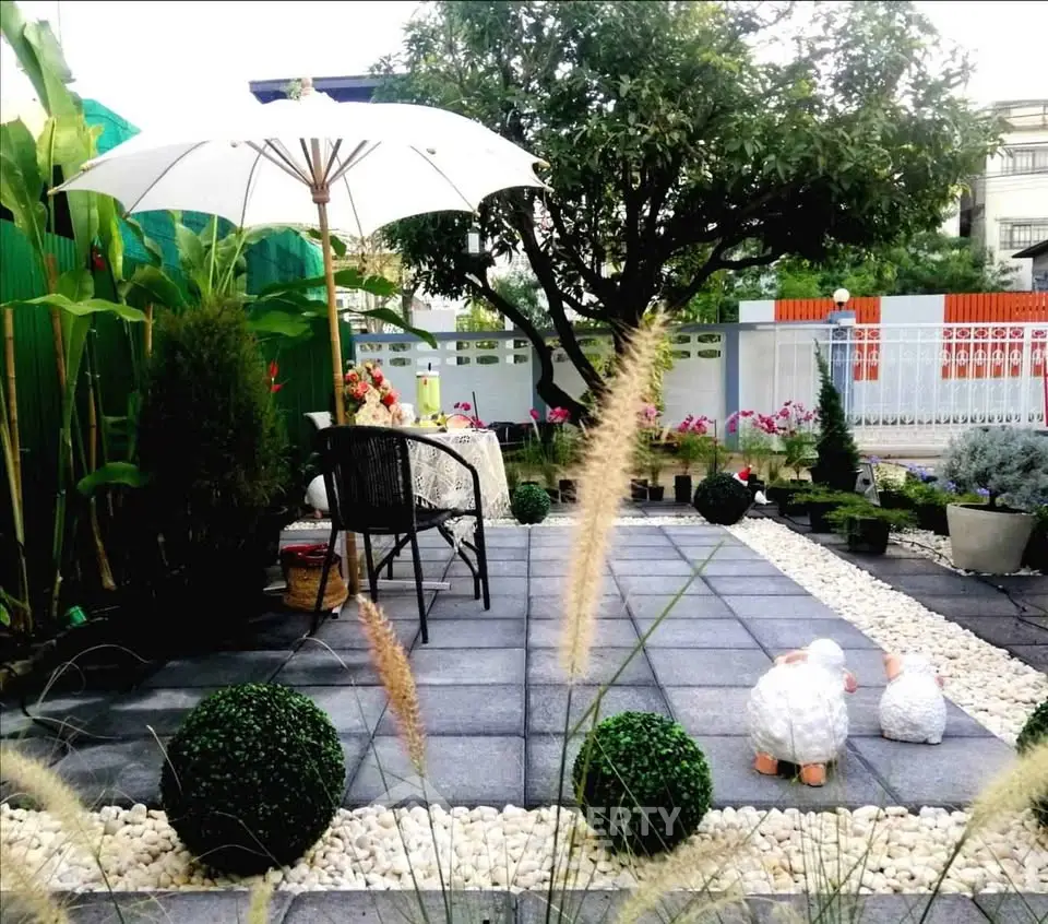Charming garden patio with elegant seating and lush greenery, perfect for outdoor relaxation and entertaining.