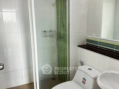 Modern bathroom with glass shower and sleek fixtures in a contemporary home.