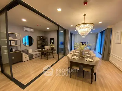 Luxurious open-plan living and dining area with elegant chandelier and modern furnishings.
