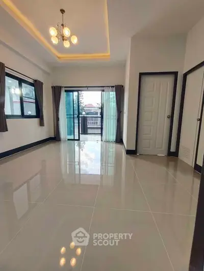 Spacious modern living room with large windows and elegant lighting, perfect for natural light lovers.