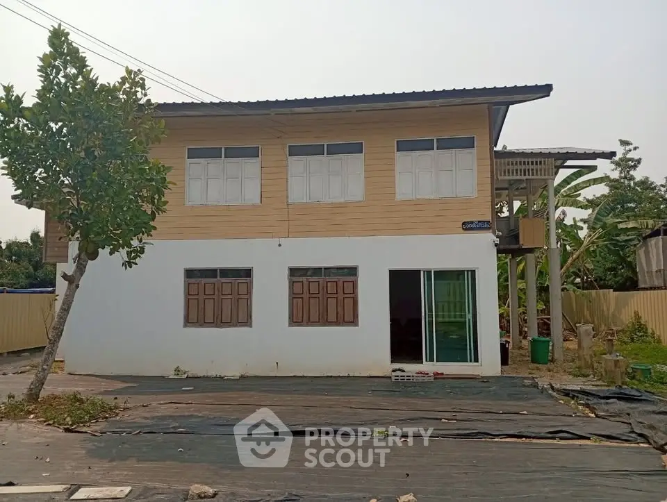 Charming two-story house with wooden accents and large windows, perfect for family living.