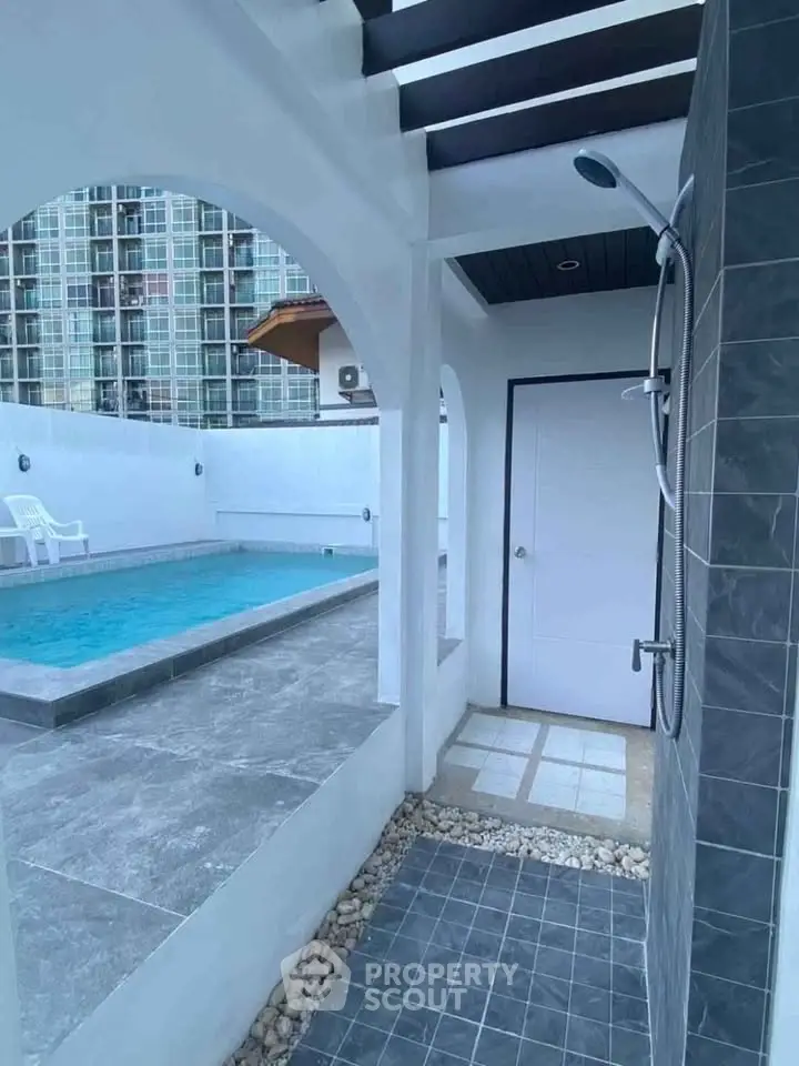 Modern poolside shower area with sleek design and city view