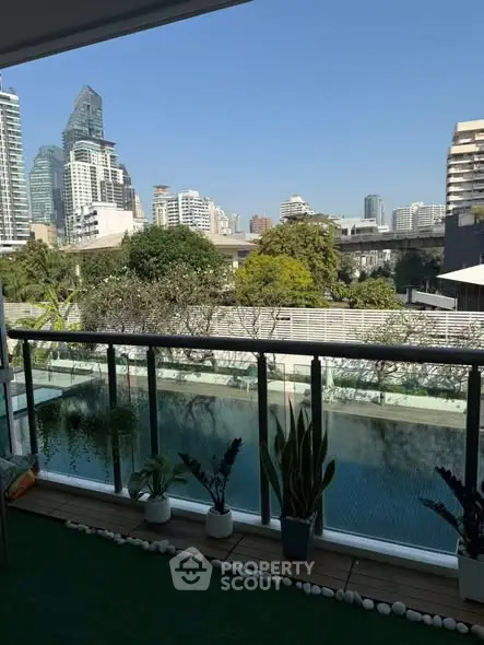 Stunning city view from a modern balcony overlooking a serene pool.