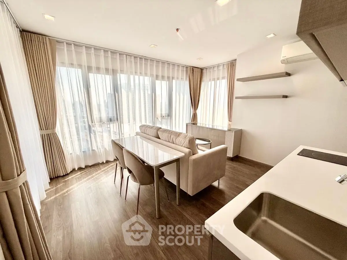 Modern living room with elegant decor and city view, featuring sleek furniture and abundant natural light.