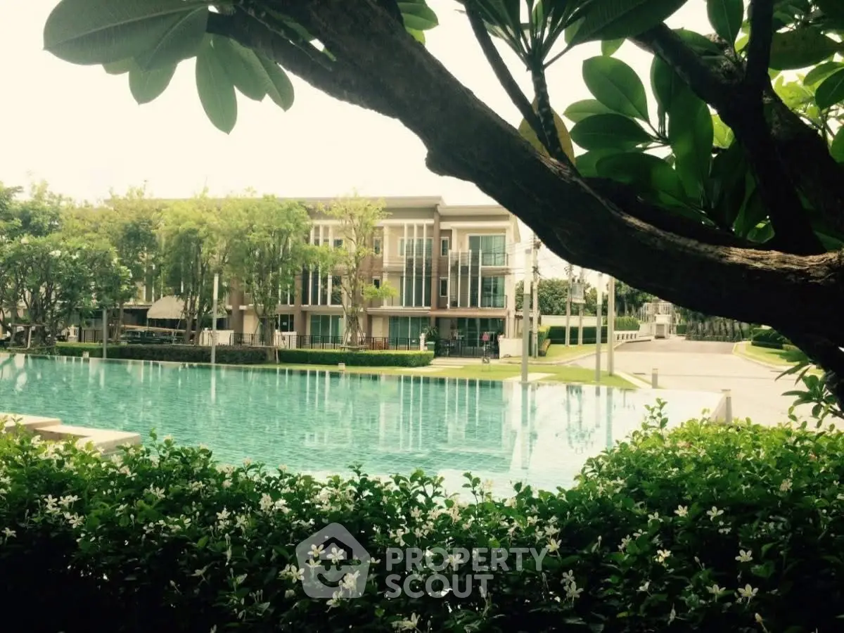 Luxurious residential building with serene pool and lush greenery, perfect for tranquil living.