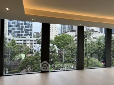 Spacious modern living room with floor-to-ceiling windows offering stunning city views.