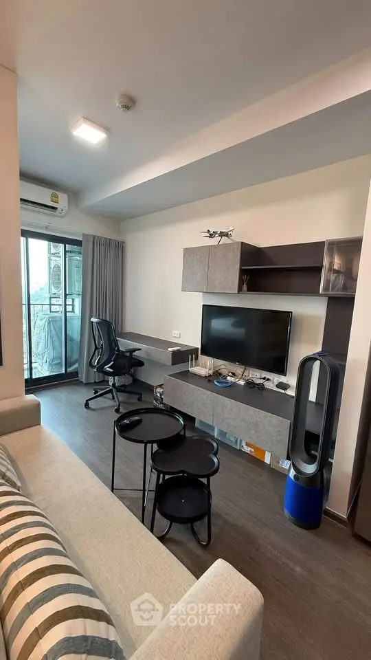 Modern living room with sleek furniture and balcony view in a stylish apartment.
