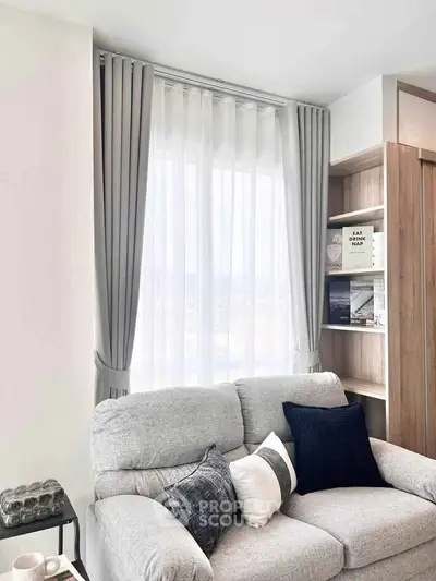 Cozy living room with elegant curtains and stylish sofa, perfect for relaxation.