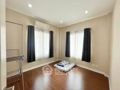 Minimalist bedroom with wooden flooring and natural light