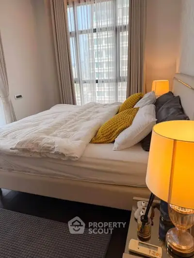 Cozy bedroom with modern decor and large windows offering natural light.