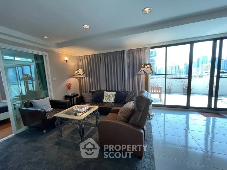 Spacious living room with large windows and city view, featuring elegant furniture and a cozy atmosphere.