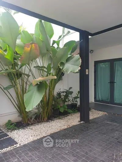 Modern home entrance with lush greenery and sleek design