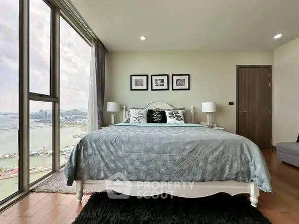 Luxurious bedroom with stunning city and sea view, featuring elegant decor and large windows for natural light.