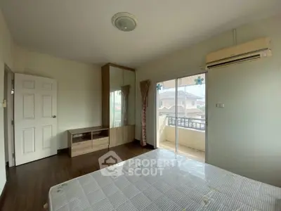 Spacious bedroom with balcony access and air conditioning in modern home