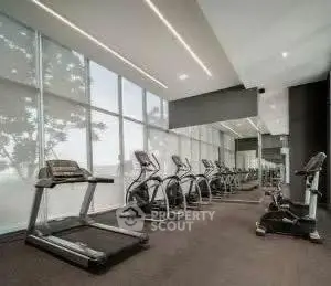 Modern gym with state-of-the-art equipment and large windows for natural light.